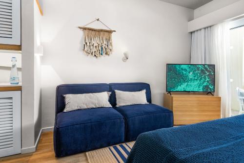 a blue couch in a living room with a tv at Lagoon Attitude (Adults Only) in Cap Malheureux