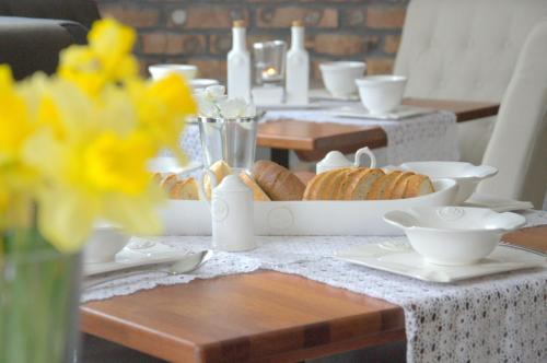 a table with a plate of croissants and a bowl of bread at Willa Sepia SPA in Wisła