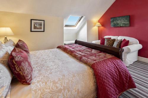 a bedroom with a large bed and red walls at Beechwood in Bowness-on-Windermere