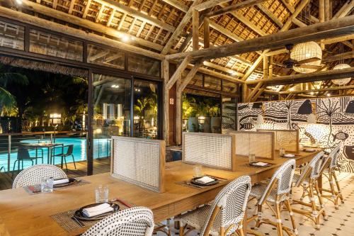 a dining room with a table and chairs and a pool at Lagoon Attitude (Adults Only) in Cap Malheureux