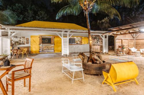 a patio with chairs and a table and a palm tree at Lagoon Attitude (Adults Only) in Cap Malheureux