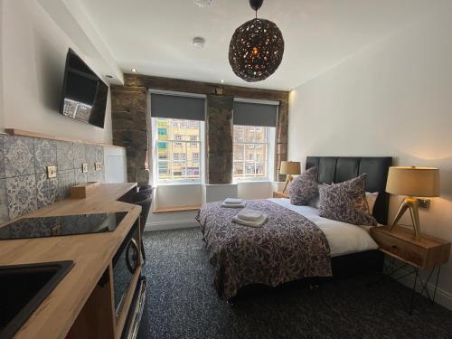 a bedroom with a bed and a kitchen with at Royal Mile Romance by Heritage Of Scotland LLP in Edinburgh