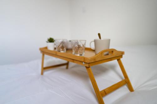 a small wooden table with cups and glasses on it at Appartement cosy dans une longère de caractère in Saumur