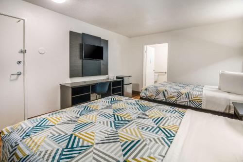 a hotel room with two beds and a television at Motel 6-Irving, TX - Dallas in Irving