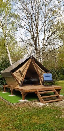a tent with two chairs on a picnic table at Camping L'oasis Du Berry in Saint-Gaultier