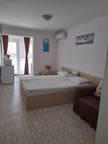 a bedroom with a large bed and a couch at Garsoniera Saturn in Saturn