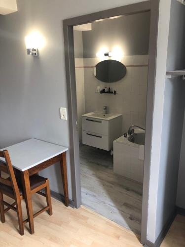 a bathroom with a table and a sink and a mirror at L'embellie in Treffort