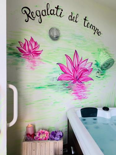 a wall with three pink flowers in the water at B&B Beauty House in Cesena