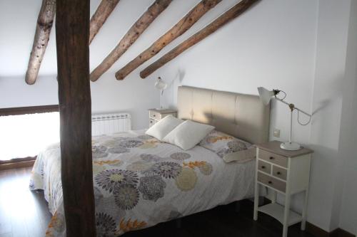 a bedroom with a bed and a table with a lamp at Apartamentos rurales 'Los Soportales' in Tendilla