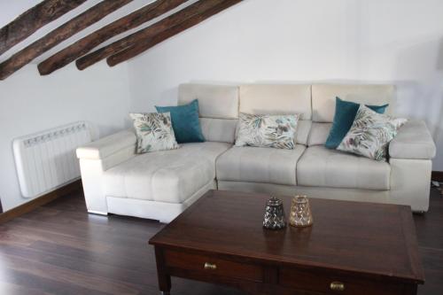 a living room with a couch and a coffee table at Apartamentos rurales 'Los Soportales' in Tendilla