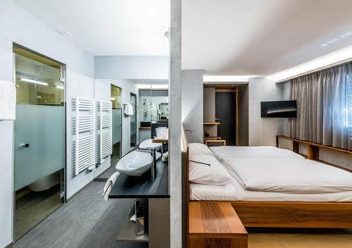- une chambre avec un lit et un lavabo dans l'établissement Hotel Farinet, à Saillon