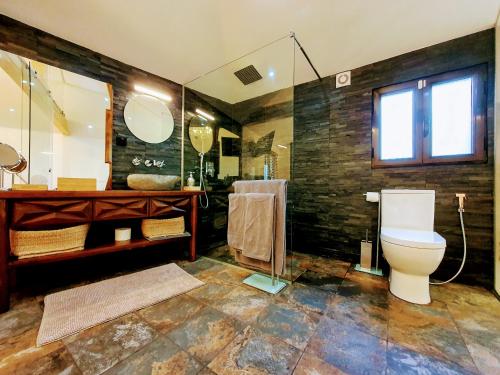 uma casa de banho com um WC e uma cabina de duche em vidro. em Casa dos Jasmins by Lisbon Village Apartments em Covilhã