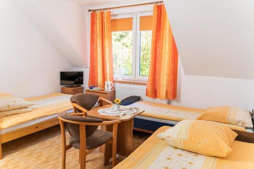 a bedroom with two bunk beds and a table and chairs at Dom Gościnny Zielono Mi in Pobierowo