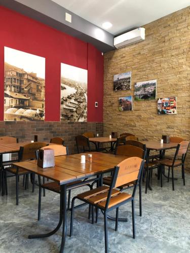 un restaurante con mesas y sillas de madera y paredes rojas en Hotel Nabadi en Tiflis