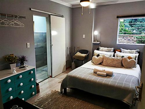 a bedroom with a bed and a dresser and a window at Waterfall Bed & Breakfast in Midrand