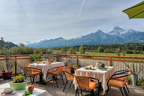 a patio with tables and chairs with mountains in the background at Theresienhof in Petschnitzen