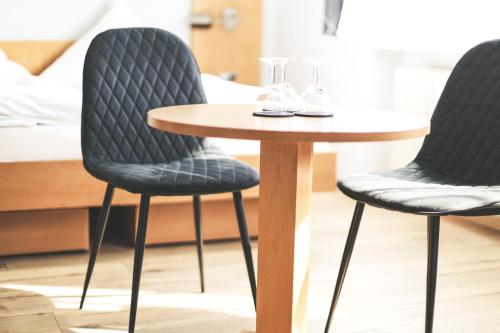 two chairs and a table in a room at Hotel & Gasthof Wagner in Aichach