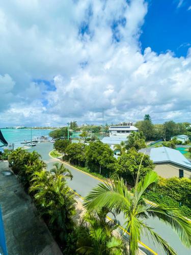 a view from the balcony of a resort with palm trees at Tripcony Quays in Caloundra
