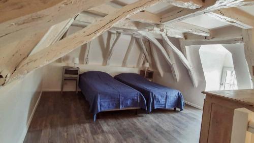 - une chambre mansardée avec un lit bleu dans l'établissement Domaine de Bagnegrole, à Saint-Cyprien