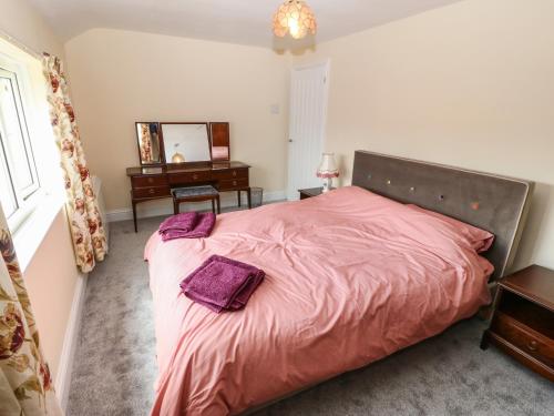 a bedroom with a bed and a desk and a mirror at Idan House in Llanfairpwllgwyngyll