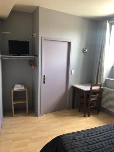 a bedroom with a door and a table and a desk at L'embellie in Treffort