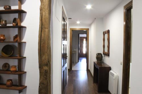 a hallway with white walls and a wooden pole at Apartamentos rurales 'Los Soportales' in Tendilla