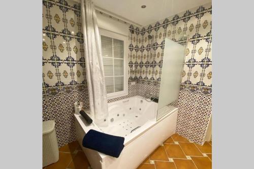 een badkamer met een bad en een raam bij Comfortable house with private pool and great view in La Mairena