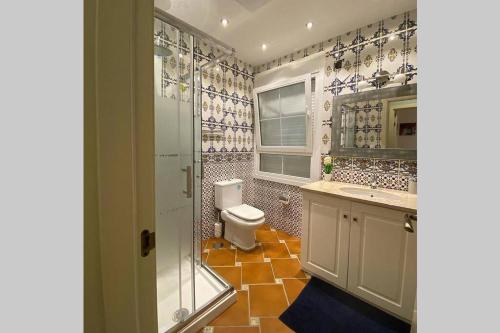 La salle de bains est pourvue de toilettes et d'une douche en verre. dans l'établissement Comfortable house with private pool and great view, à La Mairena