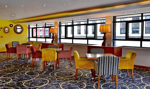a waiting room with tables and chairs and windows at Cresta Grande Cape Town in Cape Town