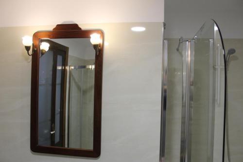 a mirror with a wooden frame on a wall at Apartamentos rurales 'Los Soportales' in Tendilla