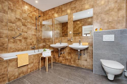 a bathroom with two sinks and a toilet at Theresienhof in Petschnitzen