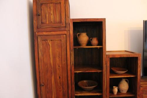 a wooden book shelf with bowls and vases on it at Apartamentos rurales 'Los Soportales' in Tendilla