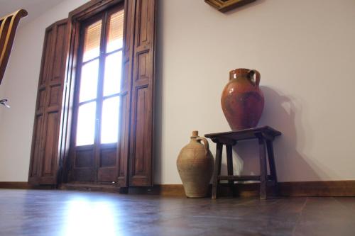two vases sitting on a table next to a door at Apartamentos rurales 'Los Soportales' in Tendilla