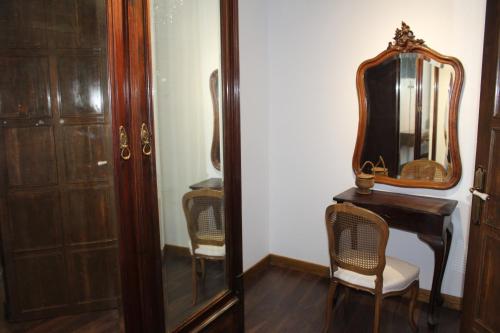 a dressing room with a mirror and a table and chairs at Apartamentos rurales 'Los Soportales' in Tendilla