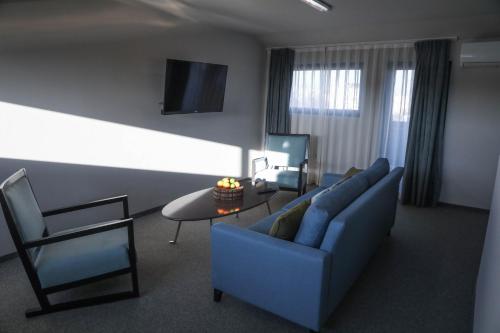 a living room with a blue couch and a table at Hotel Kanyon in Sofia