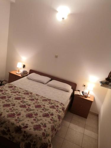 ein Schlafzimmer mit einem Bett und zwei Nachttischen mit Lampen in der Unterkunft Zahner studio in Pitsidia