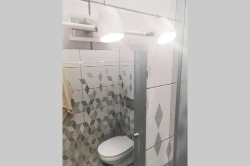a bathroom with a toilet and two lights at Self check in/out. 4 can stay. Free parking. Lejas 5a-25. in Riga