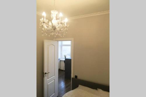 a room with a chandelier and a hallway at Self check in/out. 4 can stay. Free parking. Lejas 5a-25. in Riga