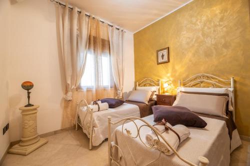 a bedroom with two beds and a window at Villa Funny in Carpignano Salentino