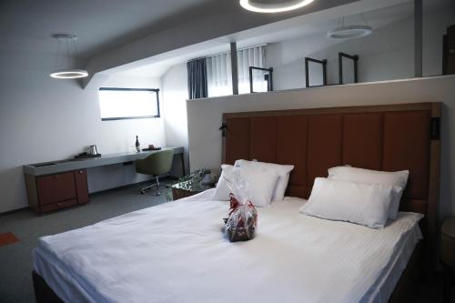 a bedroom with a large white bed with white pillows at Hotel Kanyon in Sofia