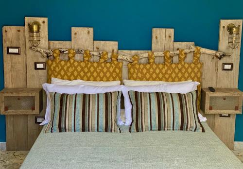 a bed with a wooden headboard in a room at HABITARE Lecce & Salento in Lecce