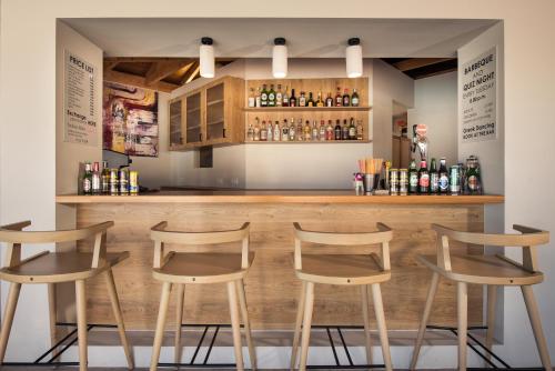 a bar with four stools in front of it at Paradise Elegant Apartments - Perfect escape on the beach in Alykes