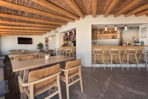 a restaurant with tables and chairs and a bar at Paradise Elegant Apartments - Perfect escape on the beach in Alykes
