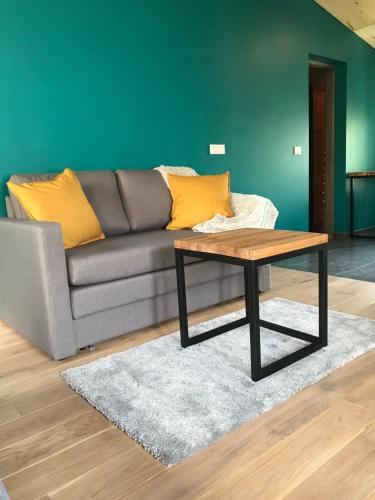 ein Wohnzimmer mit einem Sofa und einem Couchtisch in der Unterkunft Daukanto apartamentai in Anykščiai