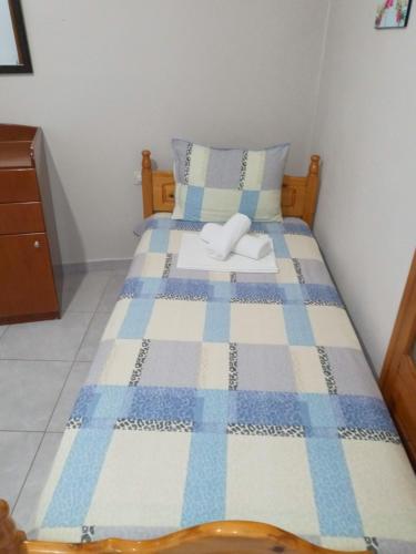 a bedroom with a bed with a blue and white quilt at AGATHA appartments PALIOURIA in Kókkinon Nerón