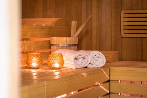een sauna met handdoeken en verlichting op een tafel bij Hotel Sigmunderhof in Chienes