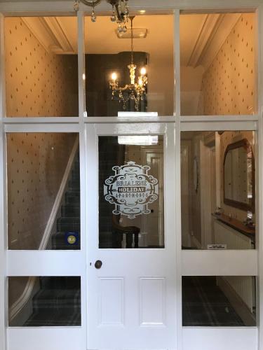 a white door with a sign on it in a room at Brialene Holiday Flats in Scarborough