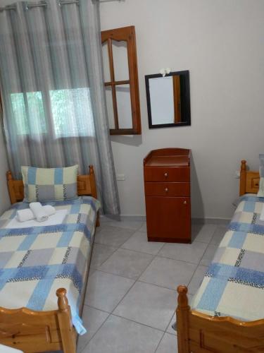 a bedroom with two beds and a dresser and a mirror at AGATHA appartments PALIOURIA in Kókkinon Nerón