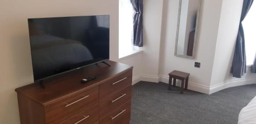 a bedroom with a flat screen television on a dresser at Glentworth Holiday Apartments in Tenby