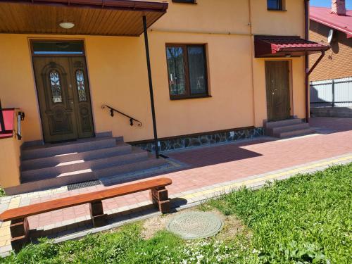 a bench in front of a house with a door at Апартаменти "Ілона" в центрі Східниці in Skhidnitsa
